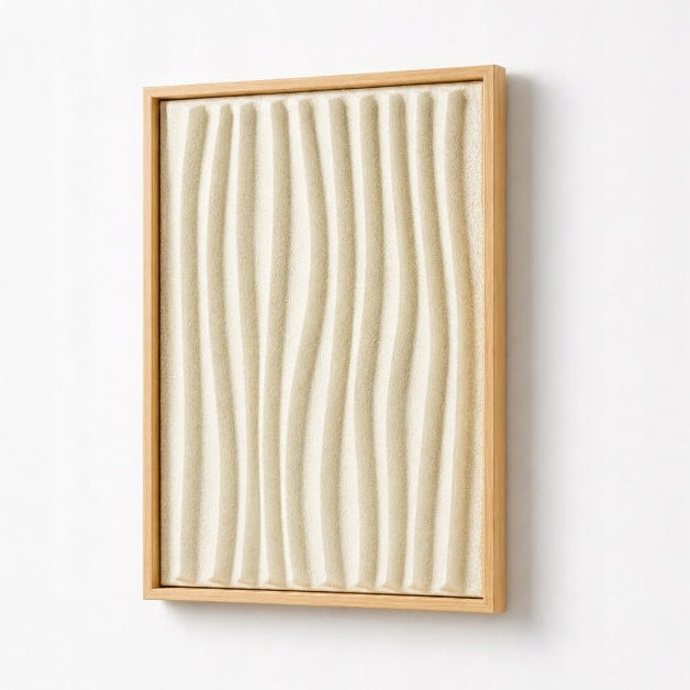 A framed abstract wall art piece featuring vertical wavy ridges in a warm cream or off-white tone, enclosed in a light natural wood frame and mounted on a plain white wall.